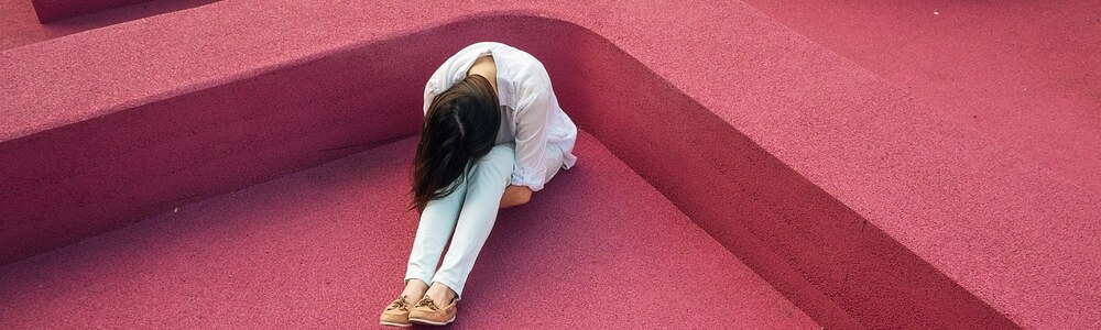 Femme recroquevillée illustrant l'attente d'être aimée pour être heureuse